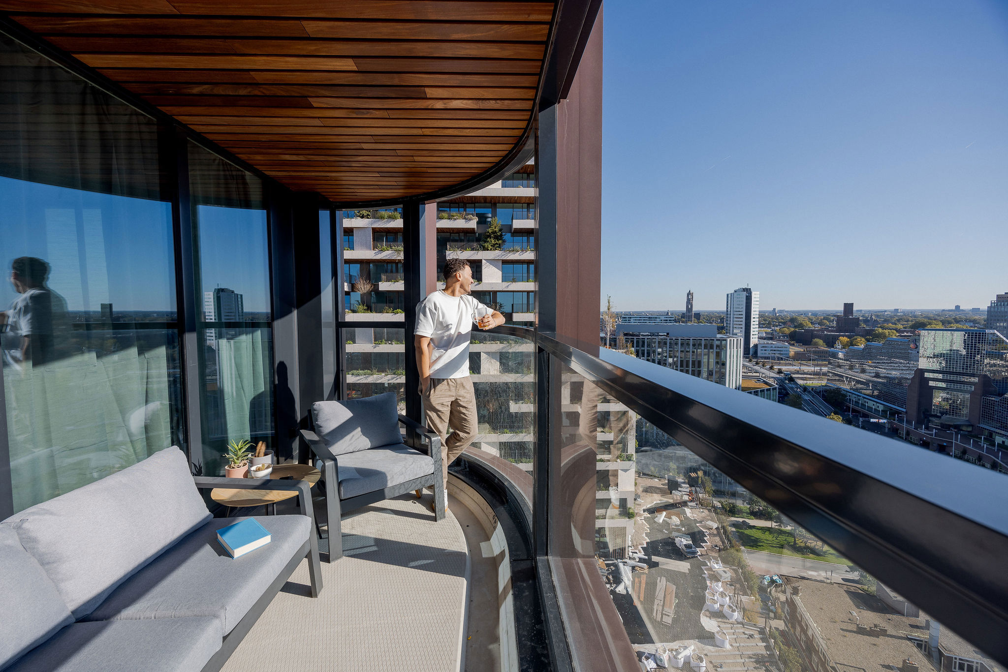 This slide displays Man kijkt uit op balkon in Wonderwoods.